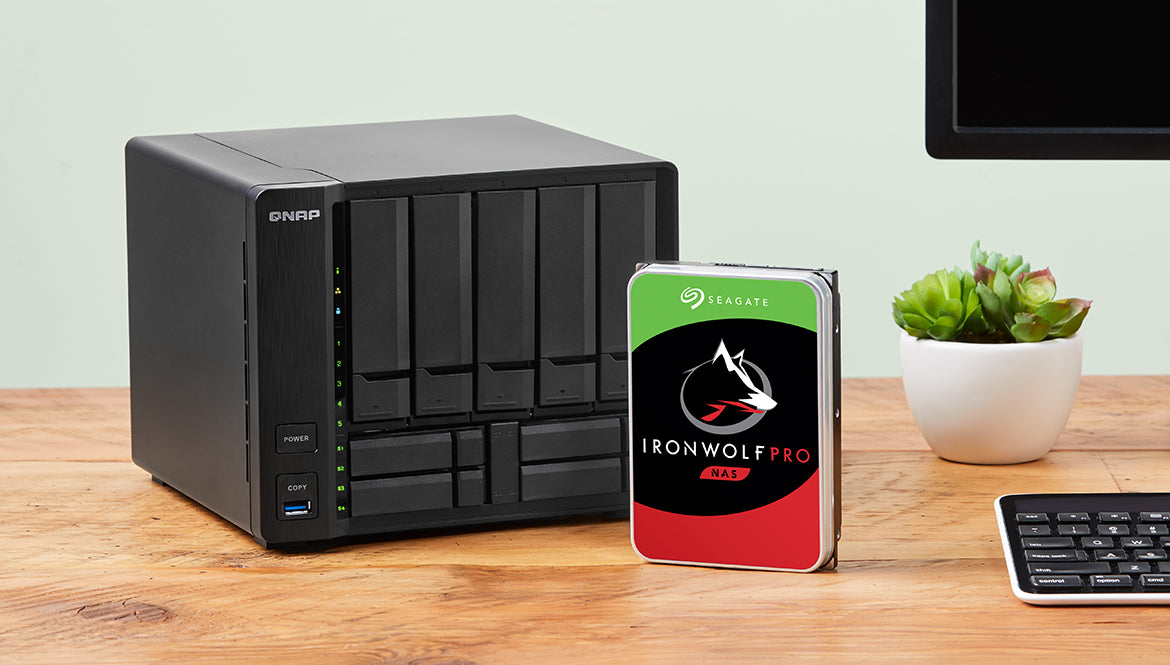 QNAP Network Attached Storage (NAS) device with Seagate IronWolf Pro hard drive on a wooden surface.